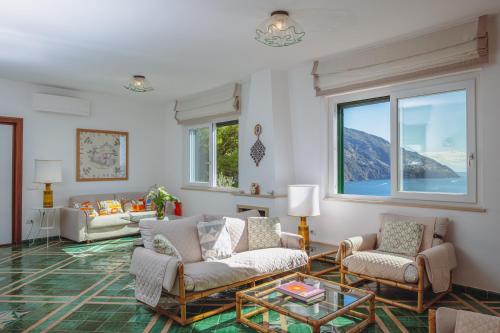 a living room with a couch and chairs and a window at POSEA Collection - Villa La Nice in Positano