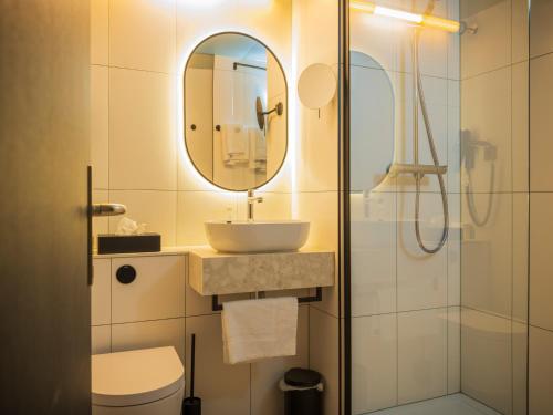 a bathroom with a sink and a mirror at Campanile Hotel & Restaurant Breda in Breda