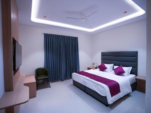 a bedroom with a large bed with purple pillows at K Hotels by SYN in Bangalore