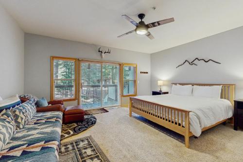 een slaapkamer met een bed en een bank bij Tavern Inn #38 in Olympic Valley