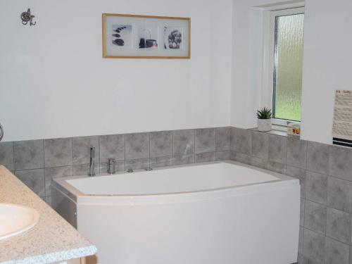 a white tub in a bathroom with a sink at 6 person holiday home in Løkken in Løkken