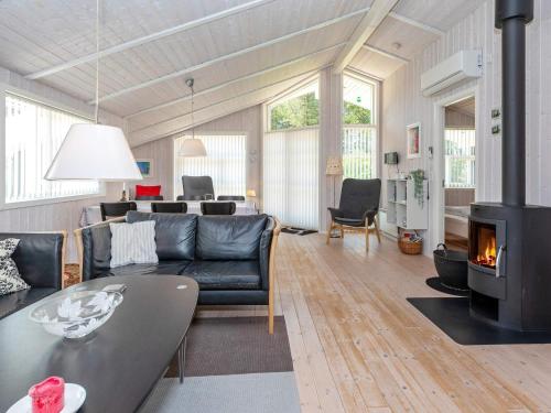a living room with a couch and a fireplace at 6 person holiday home in Løkken in Løkken