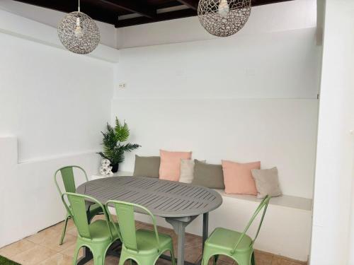 ein Esszimmer mit einem Tisch und grünen Stühlen in der Unterkunft Home2Book La Casita del Mercado in Santa Cruz de Tenerife