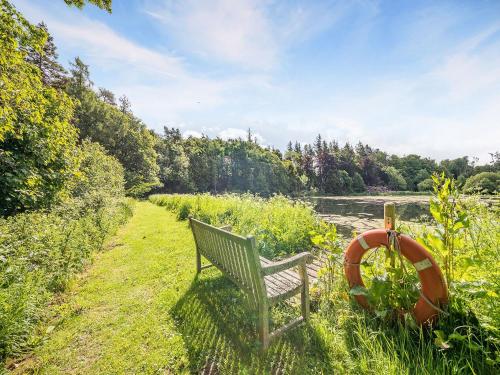 PrestonにあるShellrigg - Uk49891の川の横の芝生に腰掛けたベンチ