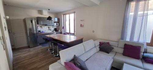 a living room with a white couch and a table at Maison Bellocier - Quartier gare in Sens