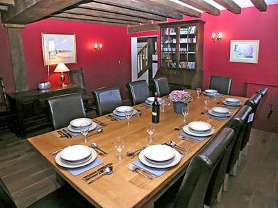 Stoneにあるソーンズデイル オストハウスの長い木製のテーブルと赤い壁のあるダイニングルーム