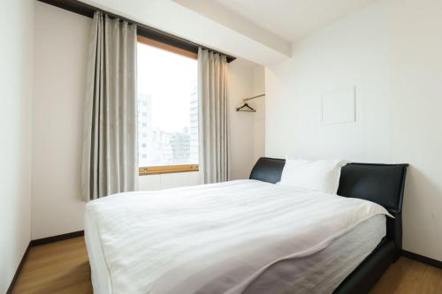 Ένα ή περισσότερα κρεβάτια σε δωμάτιο στο Nihonbashi Minshuku 義の居