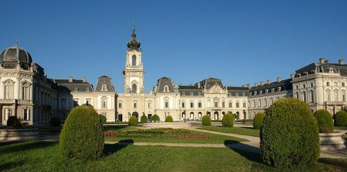 a large building with a clock tower in a park at Fabi Apart in Hévíz