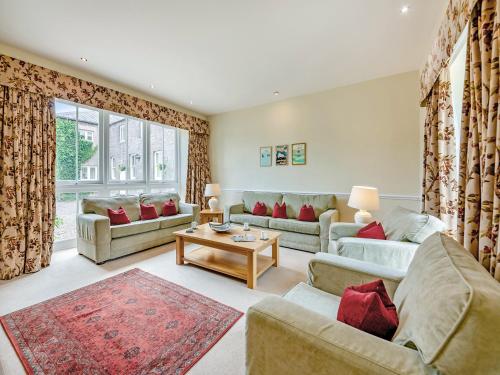 a living room with couches and a table at Doxford House - Uk49888 in Preston