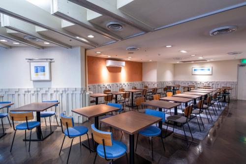 a row of tables and chairs in a room at Nest Hotel Kumamoto in Kumamoto