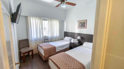マル・デル・プラタにあるArgentino Hotelのベッド2台と椅子があるホテルの部屋