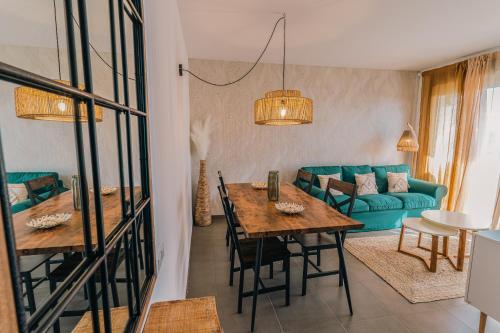 Una sala de estar con una mesa y un sofá azul. en Bella Palace, Apartamento acogedor junto al mar, en Alcanar