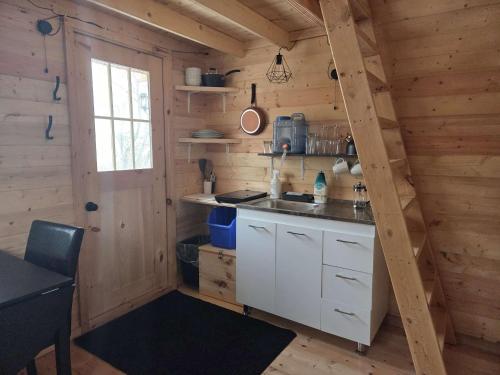 a kitchen in a log cabin with a sink and a table at #3 La Maison du Dragon in Saint-Onésime
