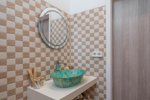 AegenitissaAmelin Villa Paradise的浴室里，洗手池上放着一个蓝色的碗，旁边还有一面镜子。