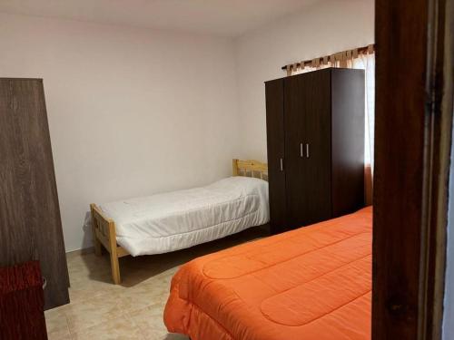 圣克莱门特雷图尤Casa Benicio - San Clemente del Tuyú的一间卧室配有两张床和梳妆台。