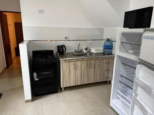 圣克莱门特雷图尤Casa Benicio - San Clemente del Tuyú的厨房配有黑炉和冰箱。