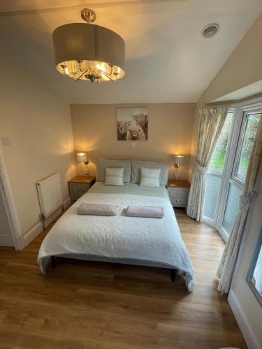 Tyes CrossにあるStunning farm retreatのベッドとシャンデリアのある寝室