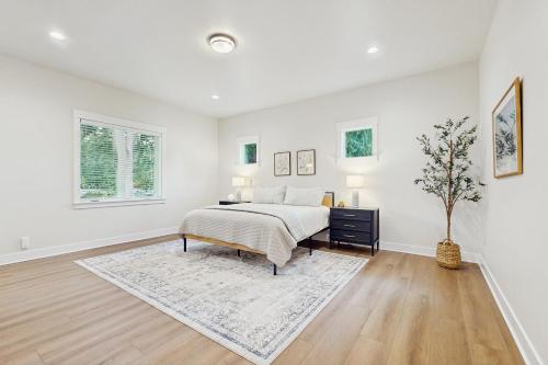 a white bedroom with a bed and a table at Lake Goodwin Retreat in Lake Goodwin
