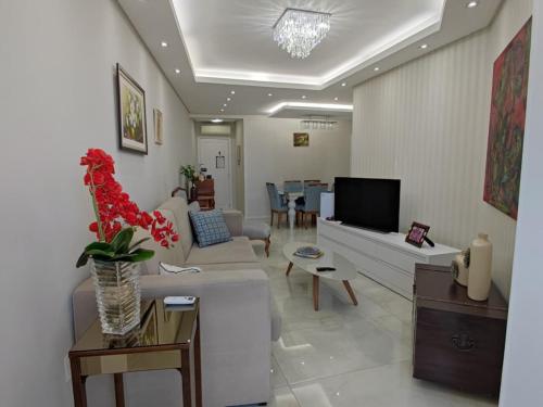 a living room with a couch and a tv at Apartment Seaview all rooms in Florianópolis