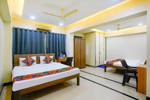 ナビムンバイにあるFabHotel Sheen Residencesのベッド2台と机と窓のある寝室