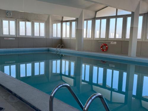 Una piscina vacía con agua azul y ventanas. en Eiffel Tower View & Pool, en París