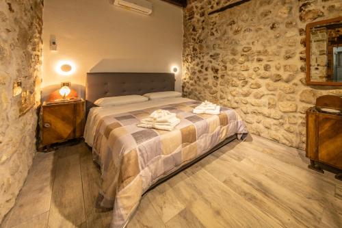 a bedroom with a bed and a stone wall at Casicarillo 800 in Serino
