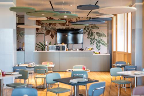 a restaurant with tables and chairs and a counter at H2C Hotel Milanofiori in Assago
