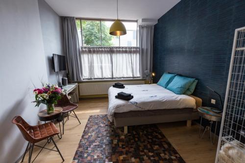 um quarto com uma cama com uma parede azul em Amsterdam House of Arts & Crafts em Amsterdã
