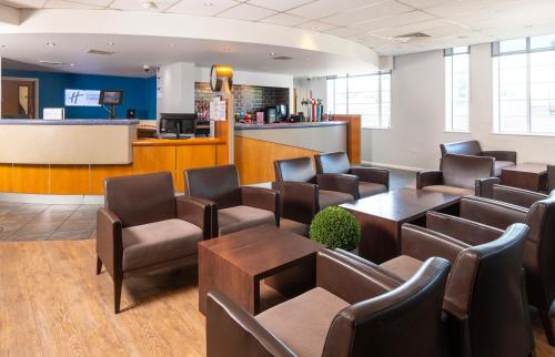 a waiting room at a hospital with chairs and tables at Holiday Inn Express London Chingford by IHG in London
