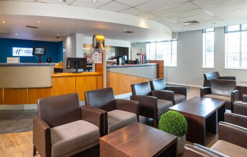 a waiting room with chairs and tables and a counter at Holiday Inn Express London Chingford by IHG in London