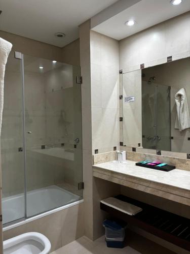 a bathroom with a shower and a tub and a sink at Plaza Hotel in La Rioja