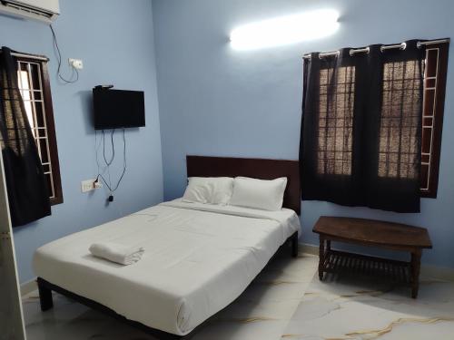 チェンナイにあるHotel O Dream innのベッドとテーブルとテレビのある寝室