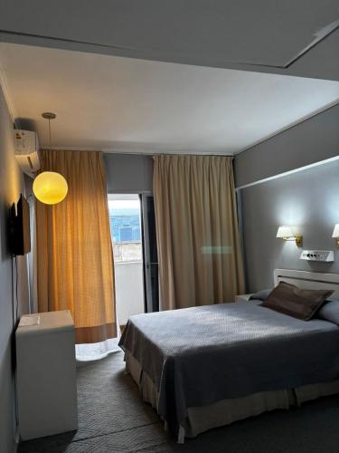 a bedroom with a bed and a large window at Plaza Hotel in La Rioja