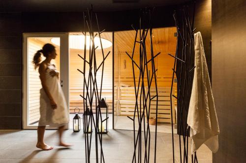 a woman walking through a room with a door at Hotel de Charme Laveno - Luxury all Inclusive in Laveno-Mombello