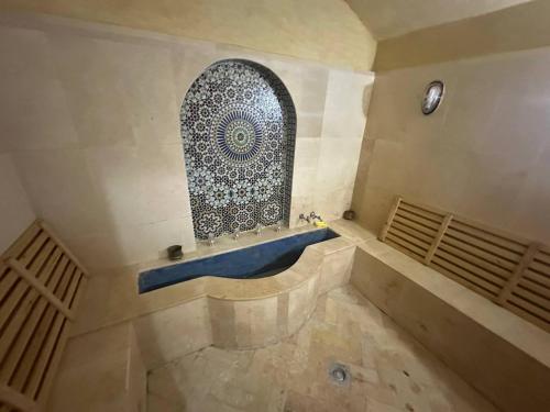a bathroom with a blue tub and a window at Dar Salma in Tangier