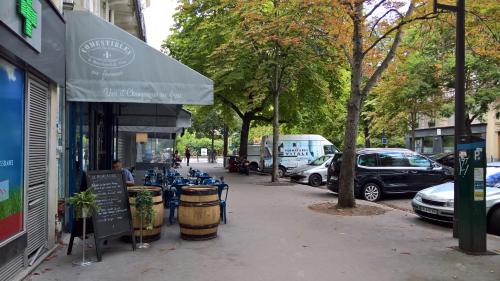 a street with cars parked in front of a restaurant at We Loft in Paris