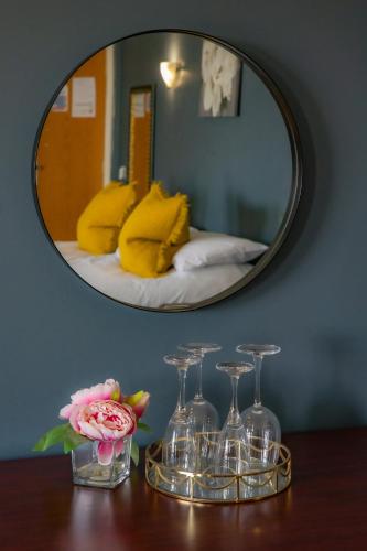 a table with wine glasses and a mirror at Bells Hotel in Coleford