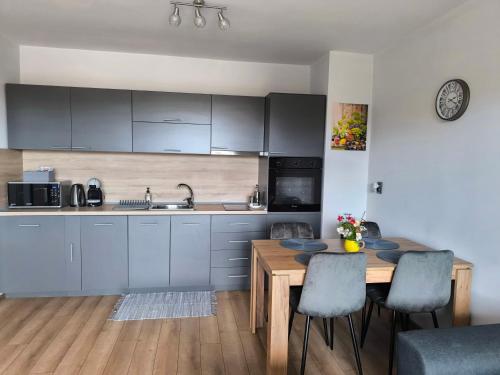 a kitchen with a wooden table and a dining room at Апартамент Славяна in Velingrad