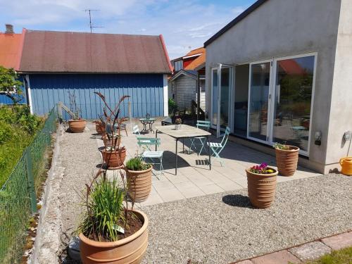 a patio with potted plants and a table in a yard at Studio apartment in Kivik in Kivik