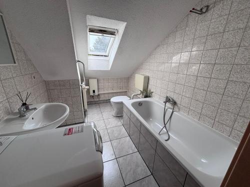 ein Badezimmer mit Waschbecken, Badewanne und Toilette in der Unterkunft AriProp Kretzschau Village Apartment in Kretzschau