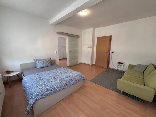 ein Schlafzimmer mit einem Bett und einer Couch in der Unterkunft AriProp Kretzschau Village Apartment in Kretzschau