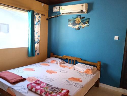 ein Schlafzimmer mit einem Bett und einer blauen Wand in der Unterkunft Gokarna beach point rooms in Gokarn