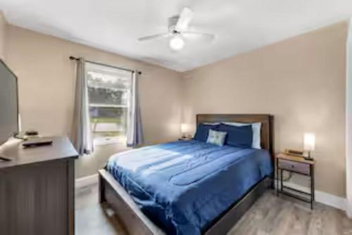 a bedroom with a blue bed and a window at Spacious 3 Bedroom in Cary