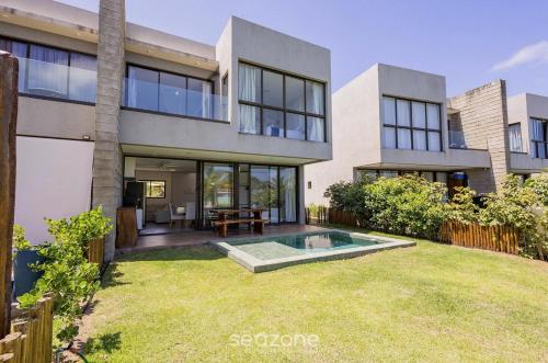 eine Außenansicht eines Hauses mit Garten in der Unterkunft Casas em condomínio à beira-mar, OKA Morada dos Milagres - GREs in Barra do Camaragibe