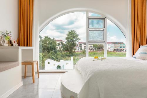 a bedroom with a large window and a white bed at Shanghai Half-Window Hotel in Shanghai