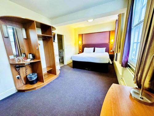 BroadheathにあるALTY Hotelのベッドと大きな窓があるホテルの部屋