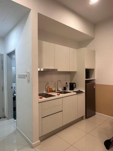 eine Küche mit weißen Schränken und einem Edelstahlkühlschrank in der Unterkunft Chambers Luxury Studio KLCC by Velvet Aurum in Kuala Lumpur