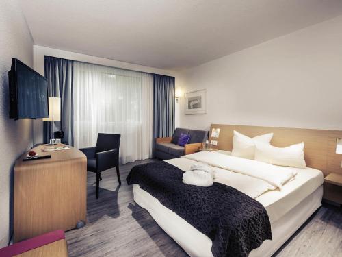 a hotel room with a large bed and a desk at Sunday Hotel Saarbrücken Süd in Saarbrücken