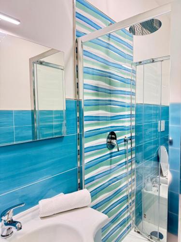 Un baño azul con lavabo y ducha. en Civico27, en SantʼAntonio Abate