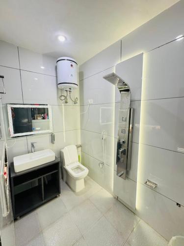 a white bathroom with a toilet and a sink at Gulmarg Palace Resorts in Gulmarg